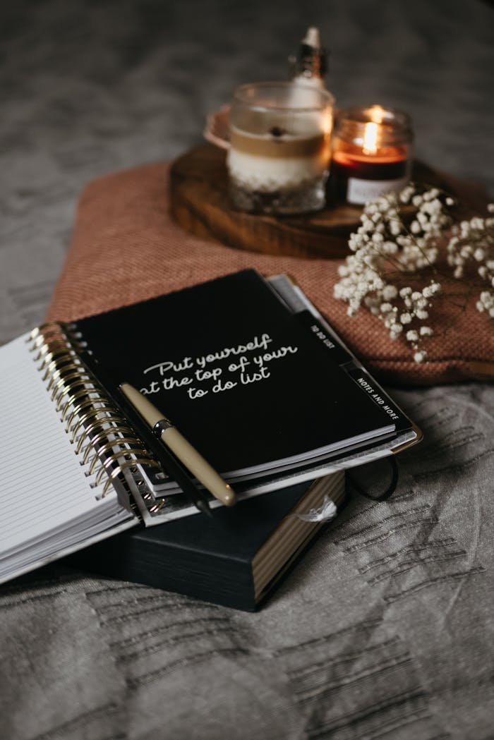 A stylish home office setup featuring a to-do list notebook, candles, and decorative elements for a cozy atmosphere.